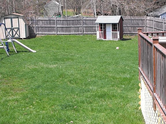Fenced in back yard with deck