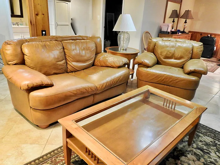 Living area with leather couch, chair and ottoman. Super comfortable and plush.