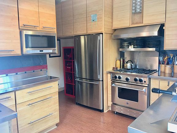 Gourmet kitchen with stainless steel appliances (high end range and hood), stainless steel countertops, custom bamboo cabinets with lots of storage, cork flooring