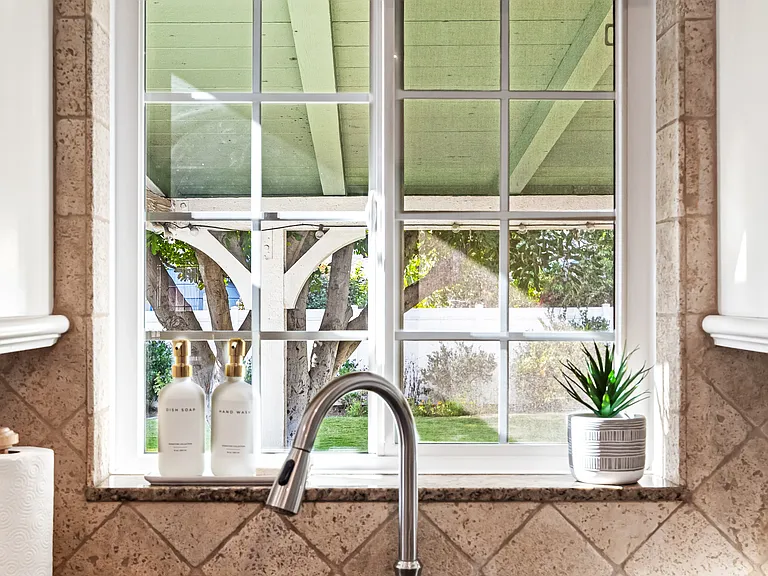 Fully stocked kitchen with abundant natural light, backyard views, bar seating, and a convenient work station for everyday living.