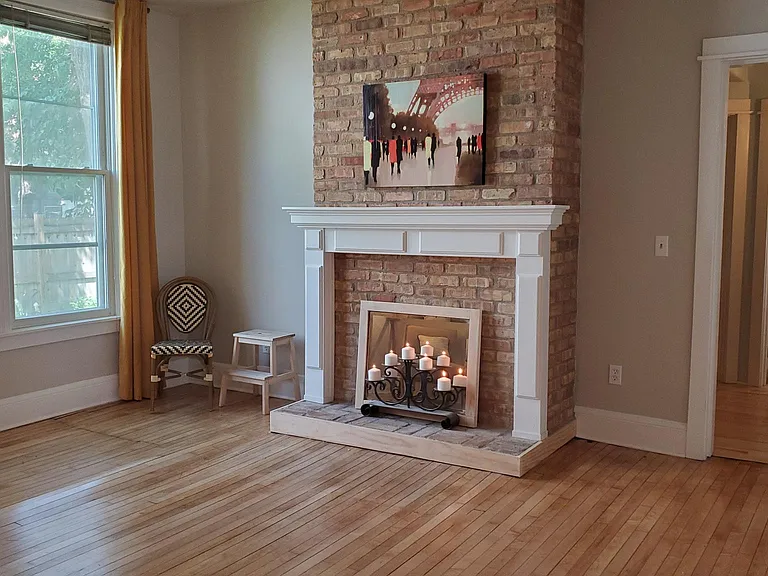 The living room has a faux fireplace creating ambiance. A TV can be placed above the mantel.