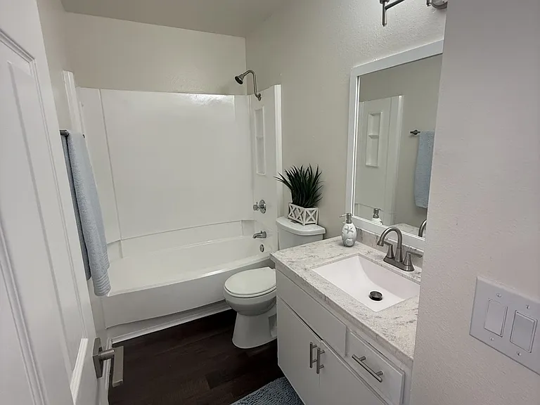 Spacious bathroom with marble countertop.