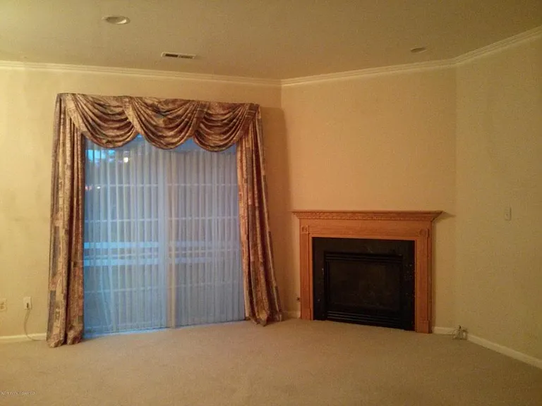 Family Living room with electric-ignited gas fireplace and sliding door leads to private patio