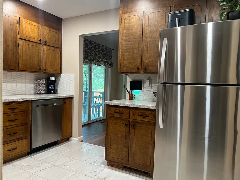 Alternate kitchen view showing the open flow to the dining area and backyard patio access.