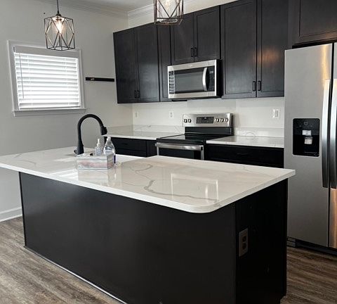 Kitchen with granite countertops, dish washer, microwave, hood vented to outside