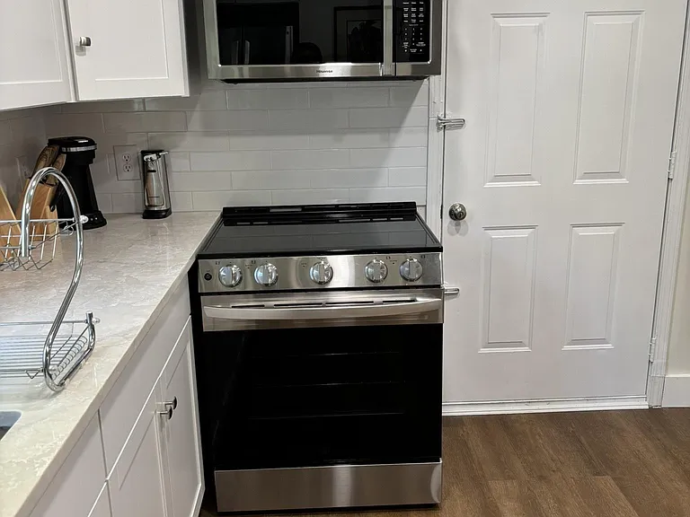 Stainless free standing electric stove and microwave. Kitchen furnished with all essentials.