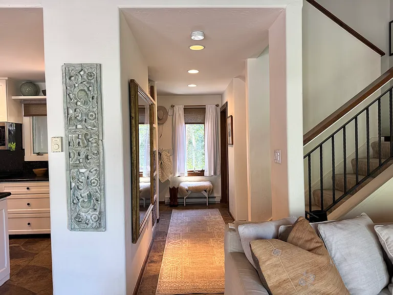 Entryway with half bath, coat closet, shelves with storage baskets, and entry to first floor bedrooms and full bath.