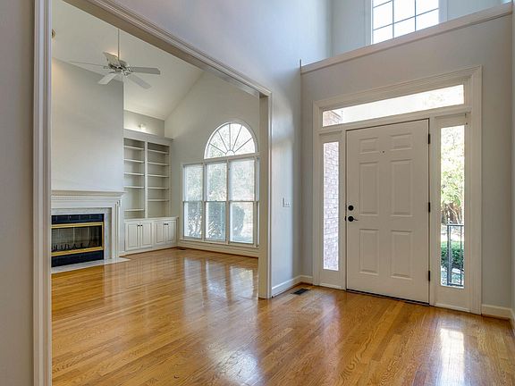 Light filled entry and living room feature vaulted ceilings with large decorative windows.