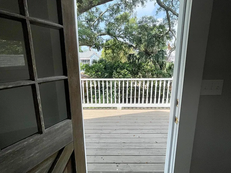 Door to back porch surrounded by green