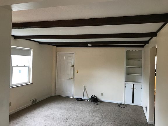 Living room, with lots of natural light. Wood beams on ceili