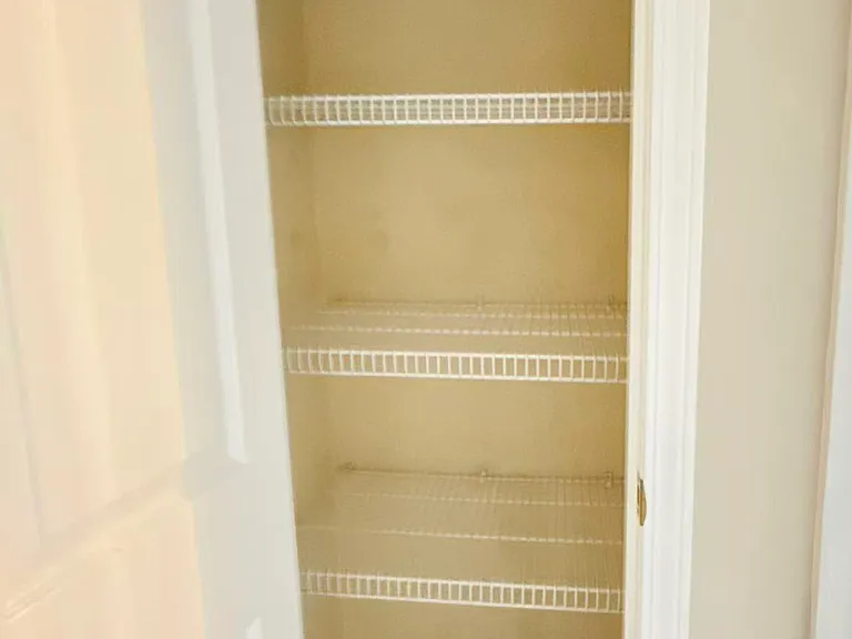 Conveniently located hallway linen closet providing extra built-in storage shelves.