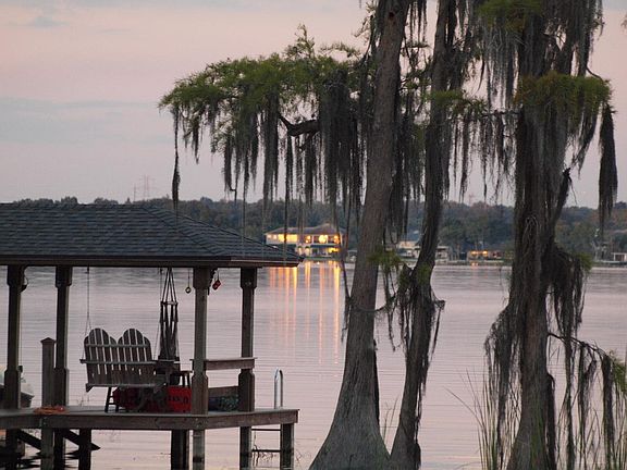 Evening sunsets make the house across the lake look like it is on fire.