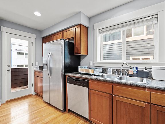 Open kitchen, dining, and living area on 2nd floor. Features covered balcony, half-bath, and gas fireplace. (Picture taken of another unit, same floor plan but mirror-imaged)