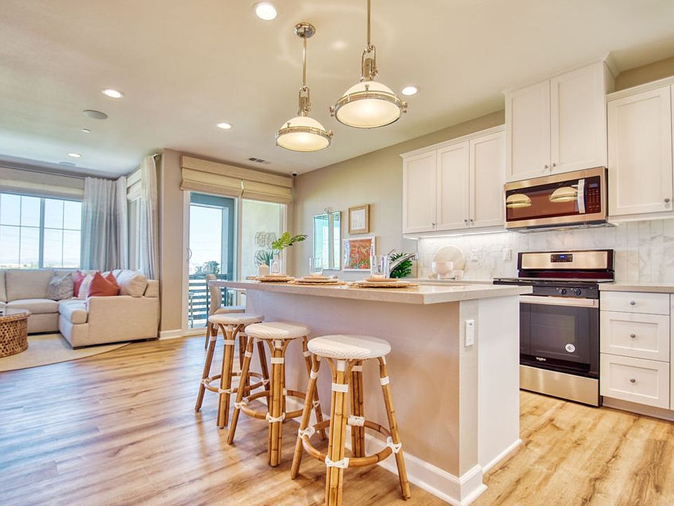 White kitchen island with pendant lighting at Citrus at Canvas Park Residence 3