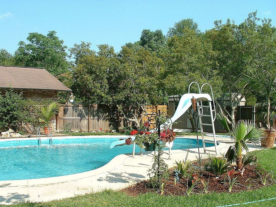 Kidney-shaped pool in the nicely landscaped back yard.