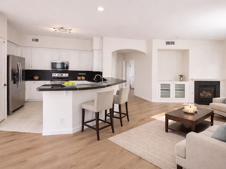 Bright open living space with 10-ft ceilings, fireplace, and access to private balcony