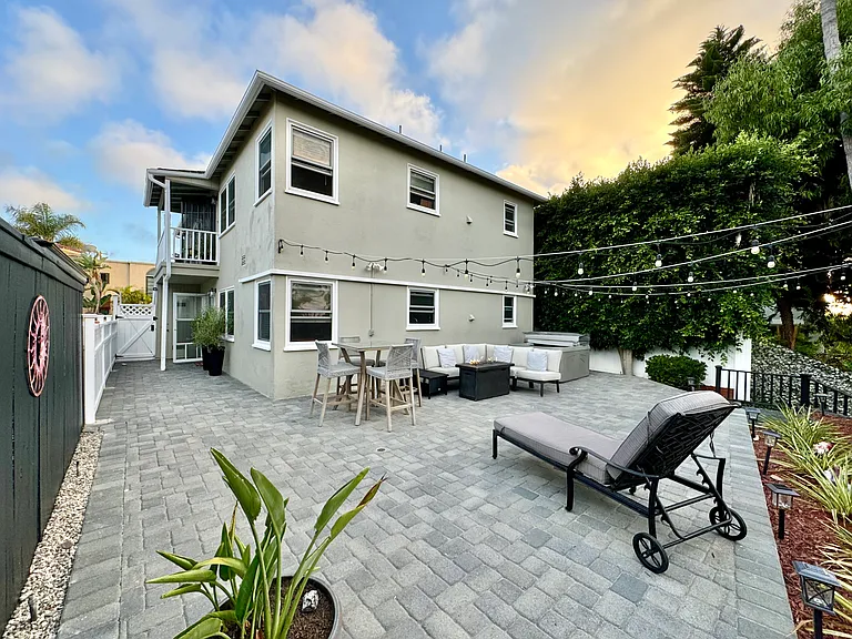 4 person hot tub, gas fire pit, outdoor seating, and outdoor dining table nestled in the canyon, with string lights and gorgeous views