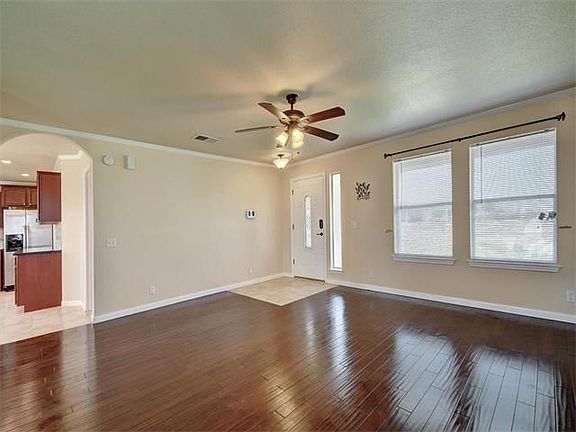 There are ceiling fans and window coverings throughout. The front door is upgraded with a glass insert.  There is an arched entryway which leads into the kitchen.