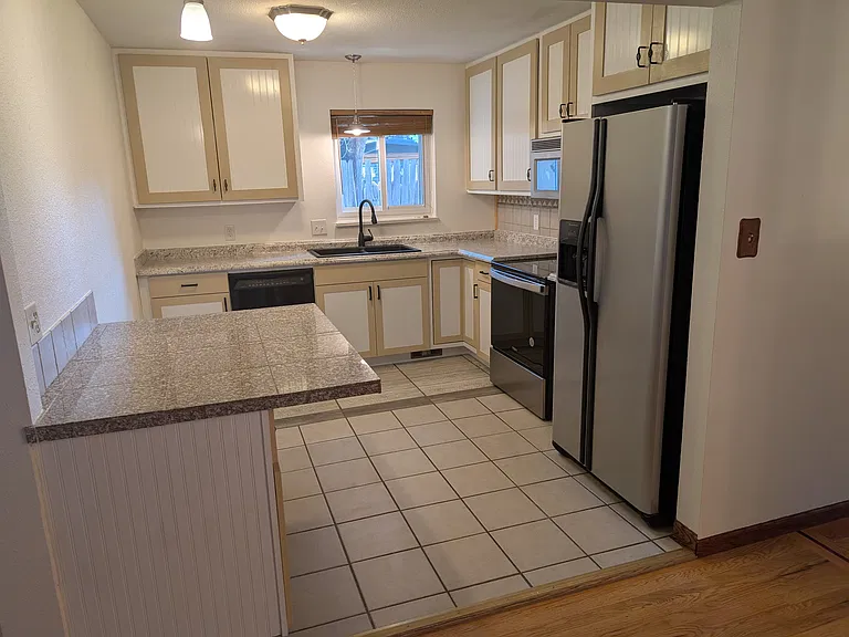 Kitchen with dishwasher, convection oven, fridge/freezer, and sink with disposal.