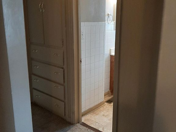 Looking toward hallway from doorway of living room; bathroom is through open door