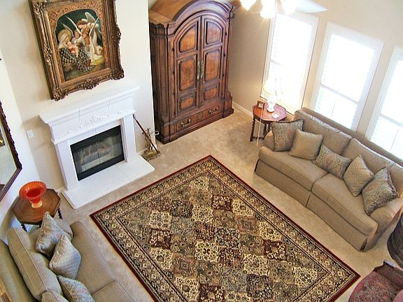 Family room has molded fireplace, huge windows and vaulted ceiling.