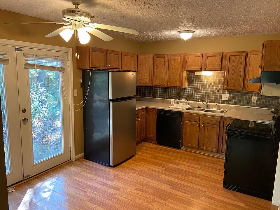 Kitchen with wood cabinets, tiled backsplash, & hardwood floors
