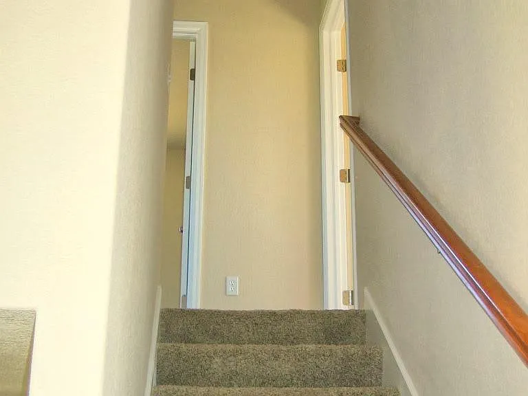Staircase to upstairs, with three bedrooms and three baths.