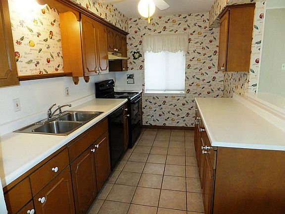 Another view of the kitchen showing its tile floor. The pantry, washer/dryer closet and guest bathro