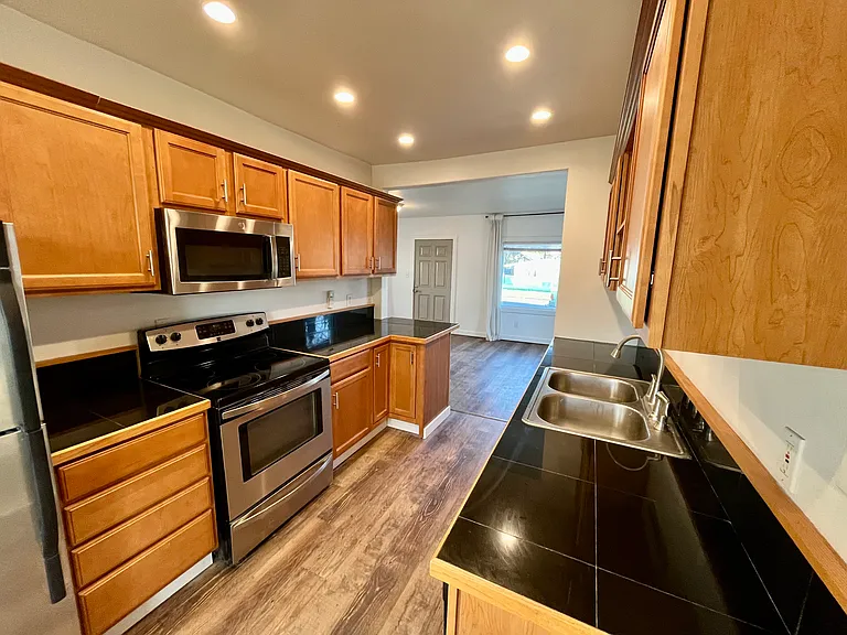 Custom Maple Cabinets & Stainless steel appliances (Fridge, Dishwasher, Microwave, Range/Oven) New LVP Flooring and white millwork throughout.