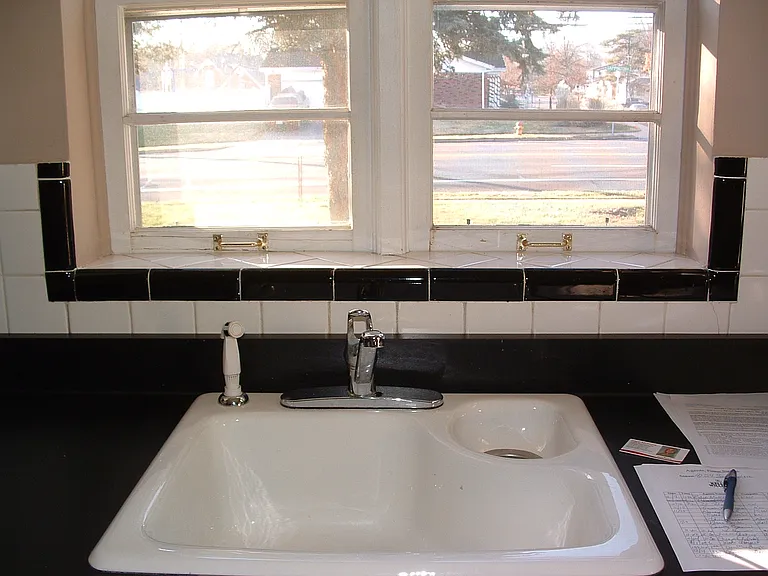 Great lighting over Retro 50's black and white kitchen sink area