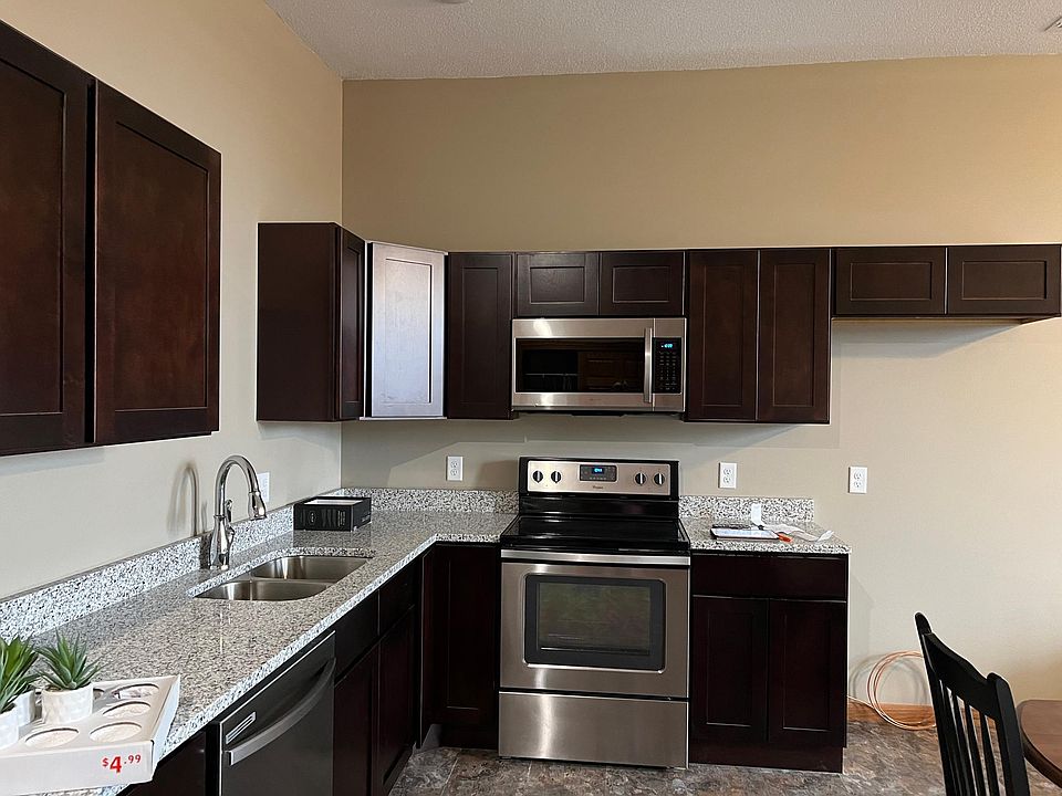 Kitchen with full size stove , microwave and refrigerator. Note the granite counter tops