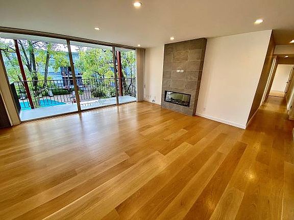 Unit #222 living room with FIREPLACE and stunning HARDWOOD FLOORS! Gorgeous views overlooking the pool!