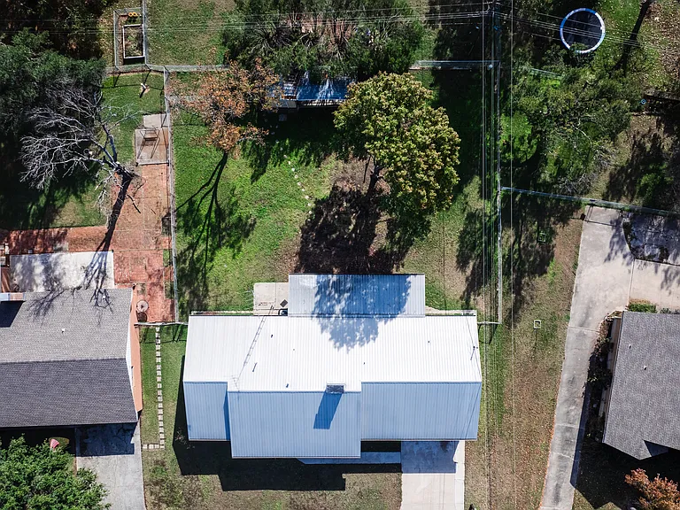 Drone aerial showing the full property from above with tree-lined neighborhood