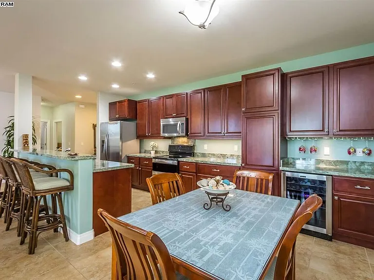 Dining table and kitchen. Wine/Beverage cooler. Electric stove with double oven, dishwasher, Side by side refrigerator/freezer/ice maker, microwave, pantry cupboard, wine glass racks, undersink Clearly Filtered water treatment.