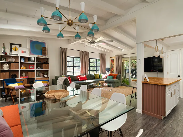 Living room features high vaulted ceilings, open floor plan, loads of natural light, ceiling fan, and laminate floors throughout. 65" TV, large cozy family-size sofa, dining table with banquette - seats 10. Books & Games