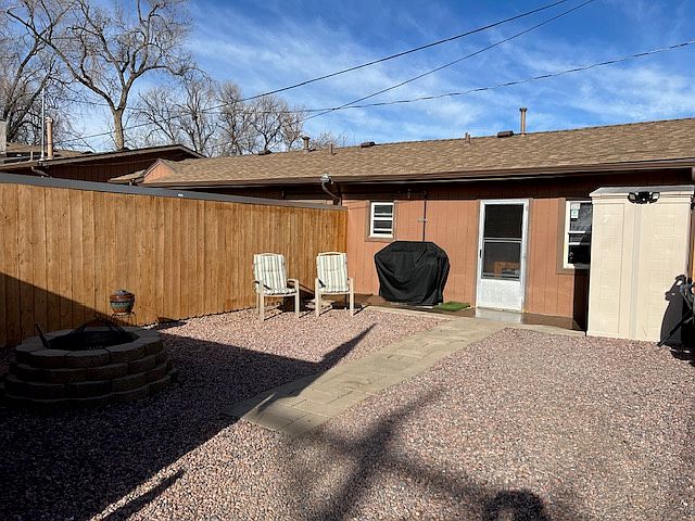 Privacy fence in backyard with storage shed and fire pit