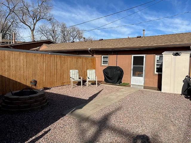 Privacy fence in backyard with storage shed and fire pit