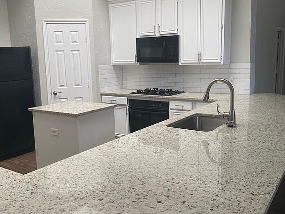 Spacious kitchen with peninsula island and large sink.