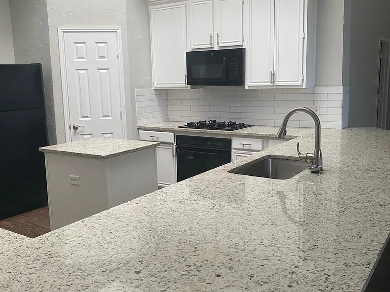 Spacious kitchen with peninsula island and large sink.