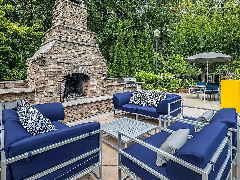 Outdoor lounge with fireplace, grilling station, and comfortable seatingperfect for relaxing and entertaining in Charlotte apartment living.