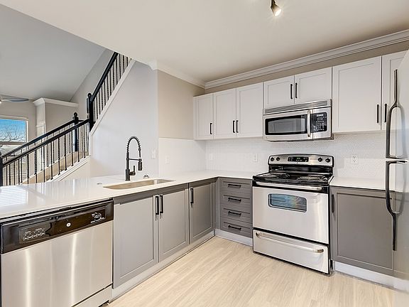 One-, two-, and three-bedroom layouts feature stainless steel appliances, hardwood-style flooring, black hardware and updated lighting fixtures