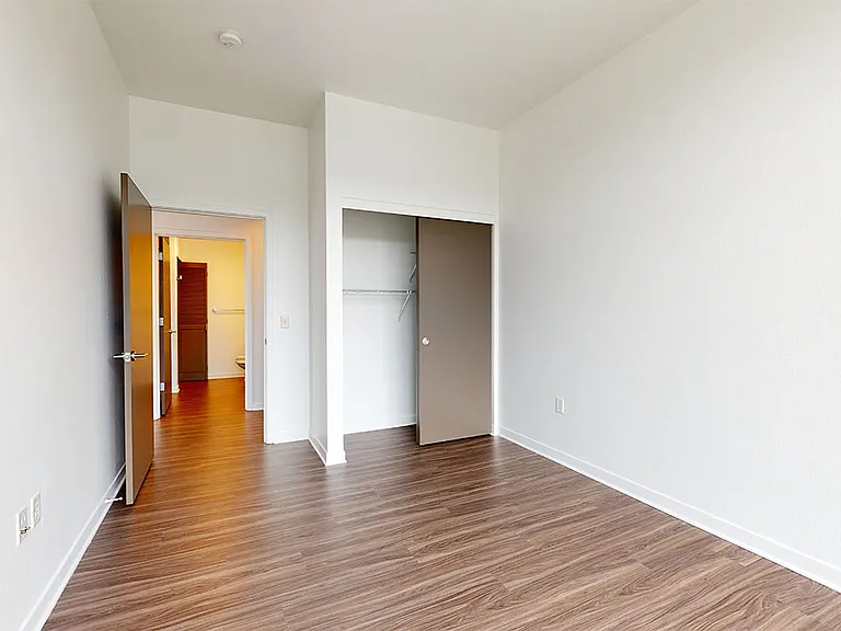 Apartment bedroom with wood-style flooring.