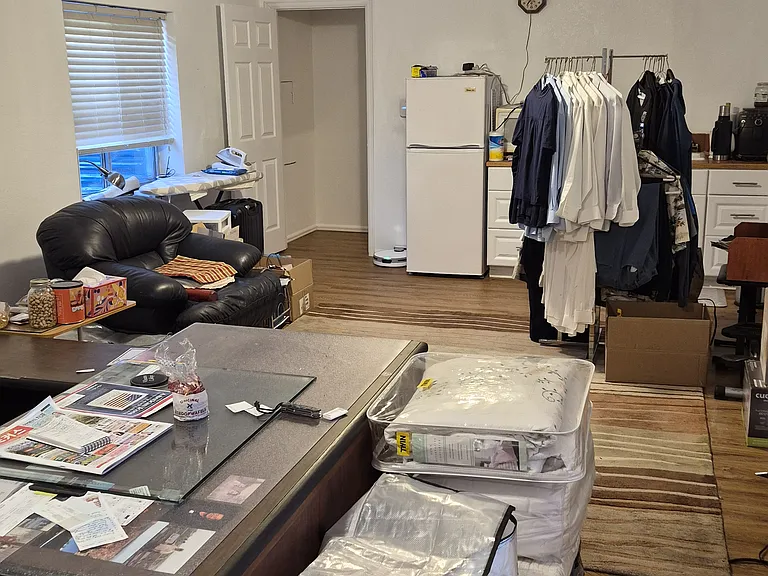 Basement living room area features a sink and storage cabinets