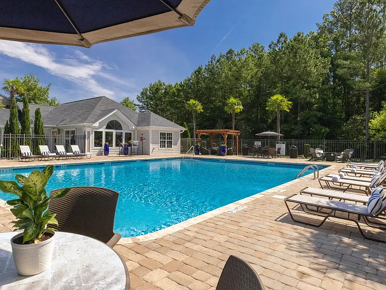 Enjoy delightful poolside seating with tables, umbrellas, and cozy loungers for your comfort around the pool.