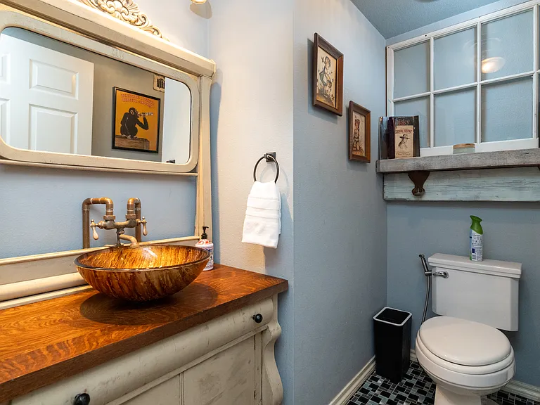 Charming half bath with rustic decor, vessel sink, and vintage touches. Cozy, stylish, and convenient for guests.