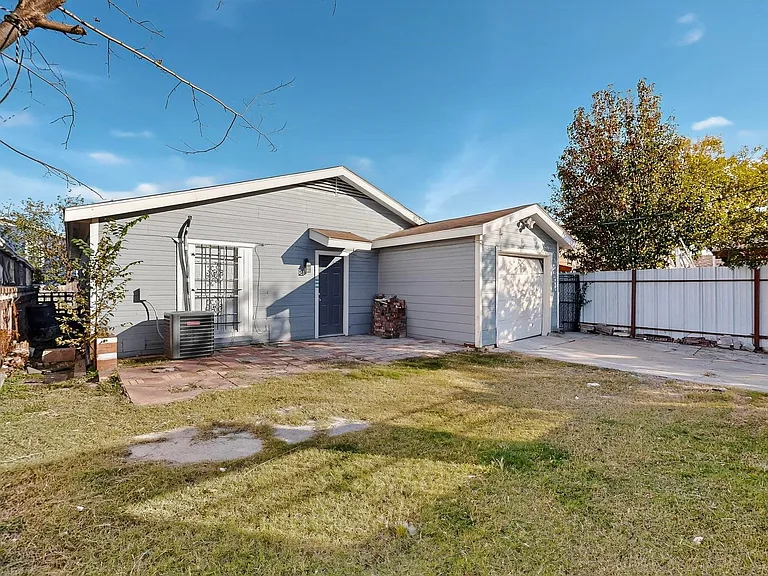 Rear view of property featuring a patio area, driveway, and an attached garage