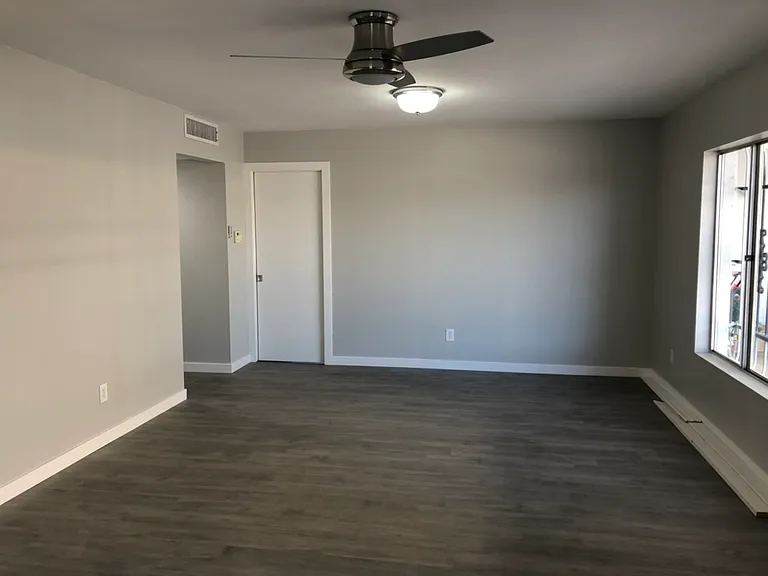 living room with pocket door to kitchen and entry to hallway, which has 5' coat closet on the left.