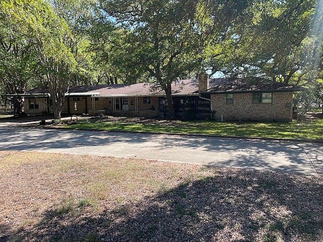 Rear view of the house - mature trees, ample driveway parking, sprinkler system
