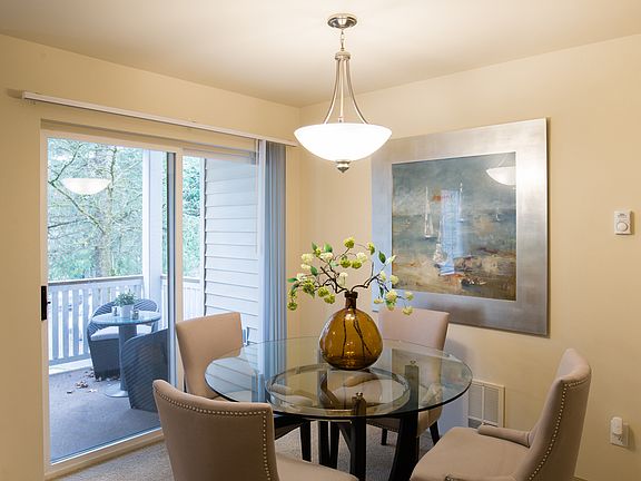 Dining area with overhead lighting and large sliding glass doors leading out to the balcony
