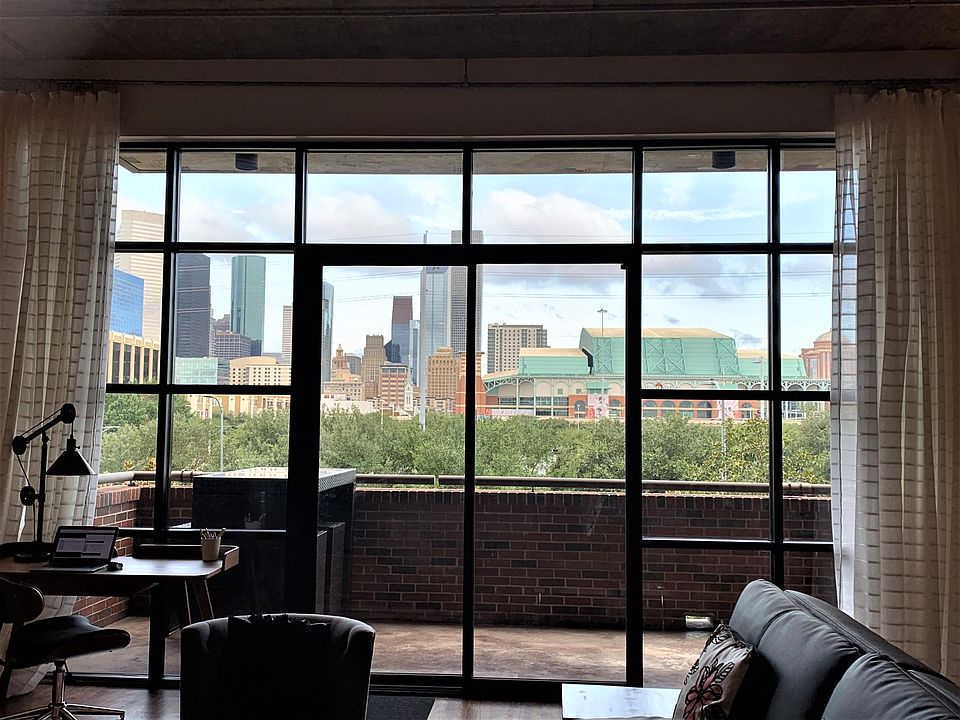 Floor-to-ceiling windows in living room for an unobstructed view of the Houston skyline and Minute Maid Park